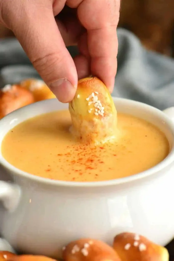 Beer-cheese-dip-dipping-in-pretzel