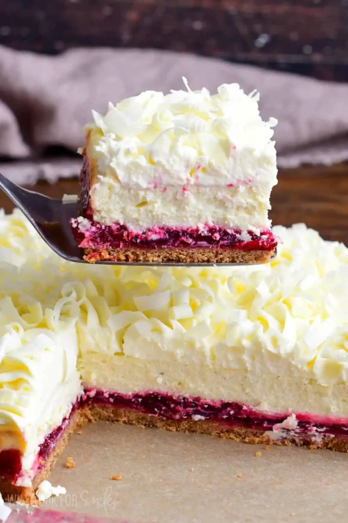 Christmas-Cheesecake-Bars-White-Chocolate-Cranberry-Cheesecake-Bars-holding-one-slice-higher